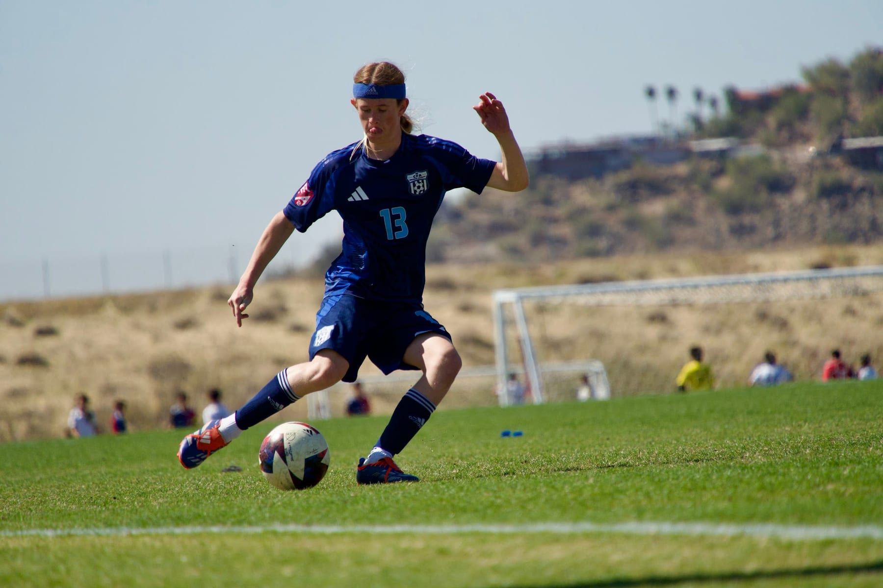 CFA boys player in navy about to strike the ball